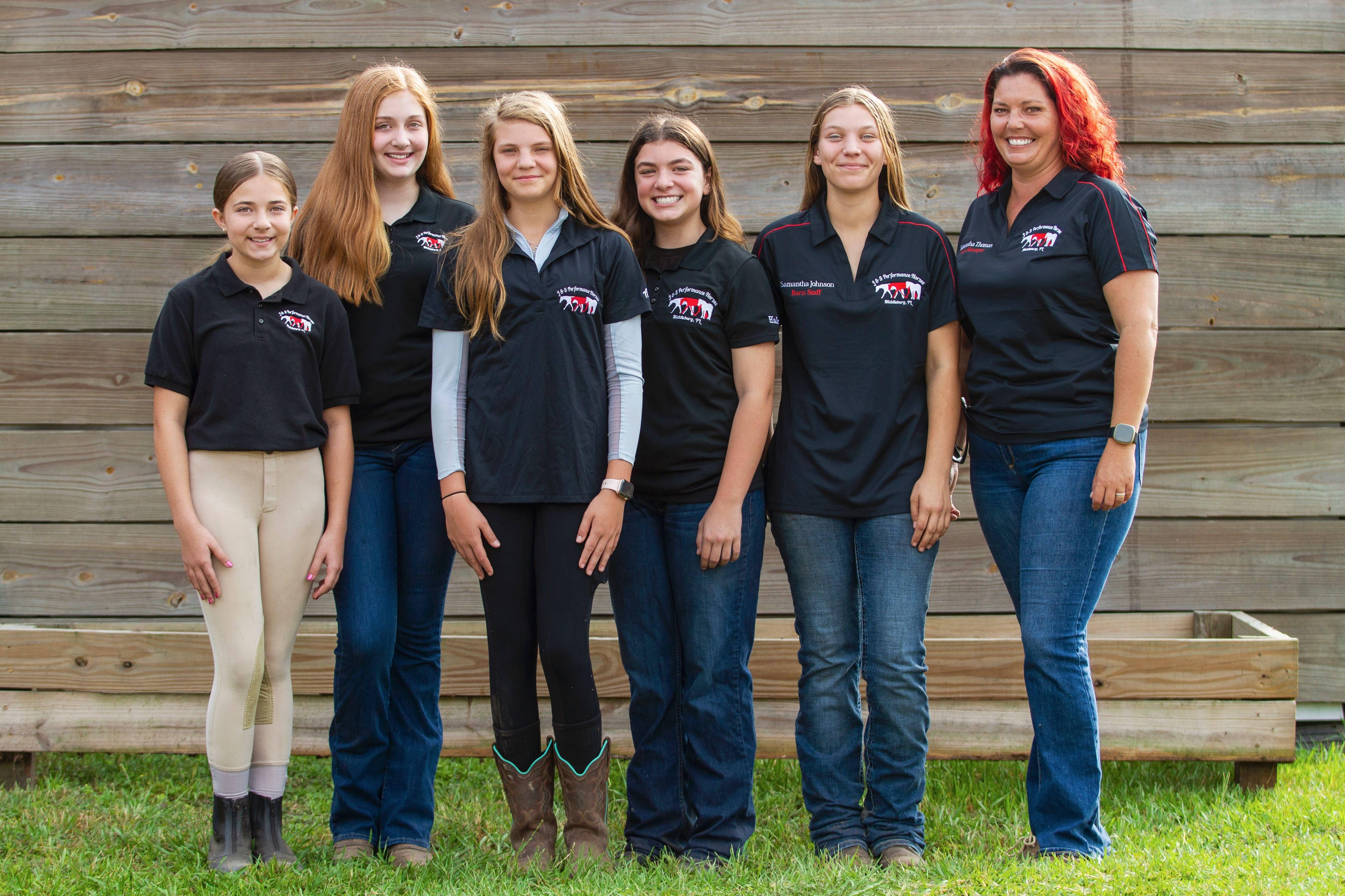 Barn manager, Samantha T., is standing in front of the main barn with five working students that help take care of the farm.